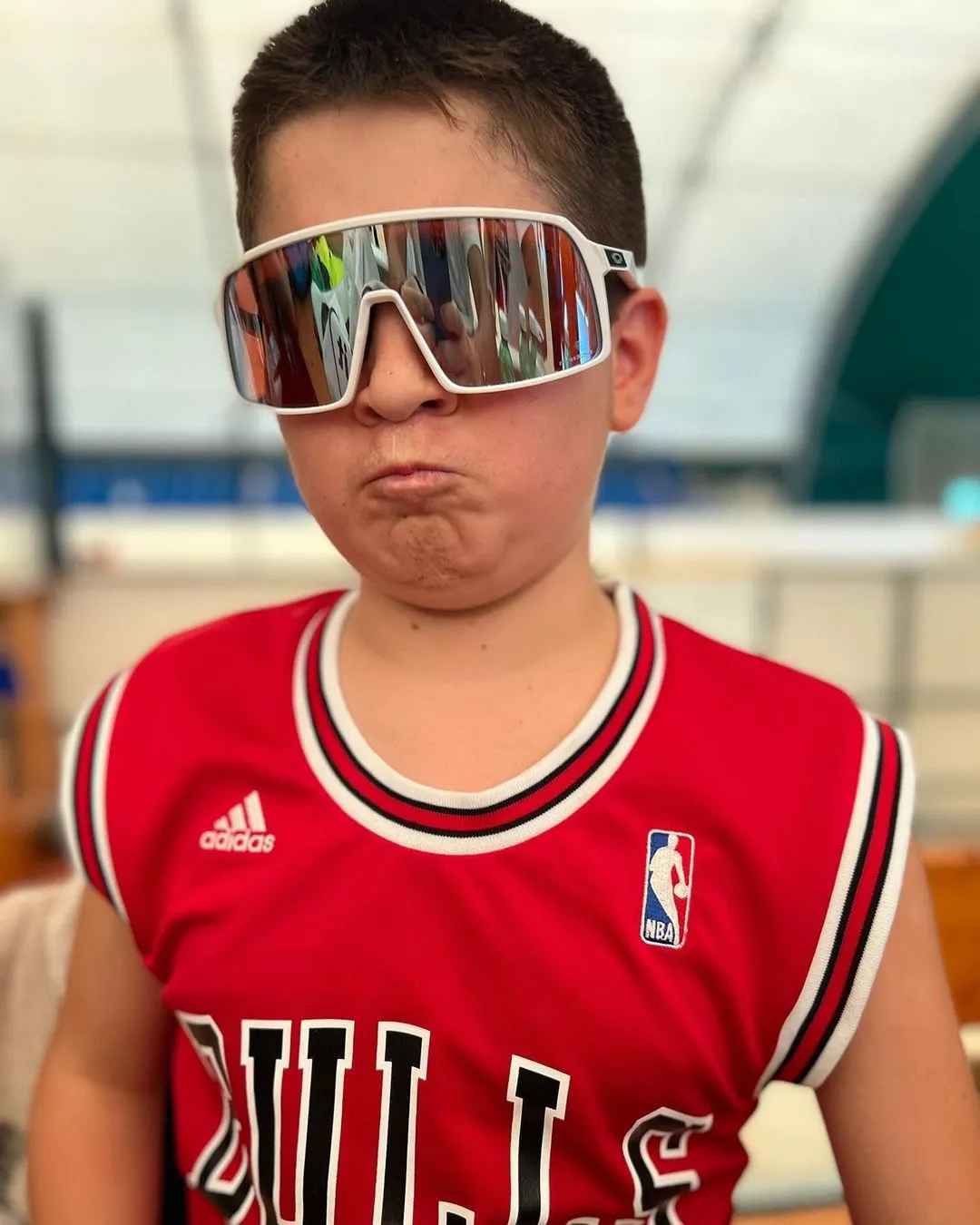 Un ragazzo del camp con occhiali da sole e canotta da basket