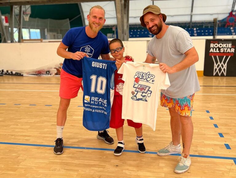 Un ospite del camp consegna una maglia a un bambino in palestra