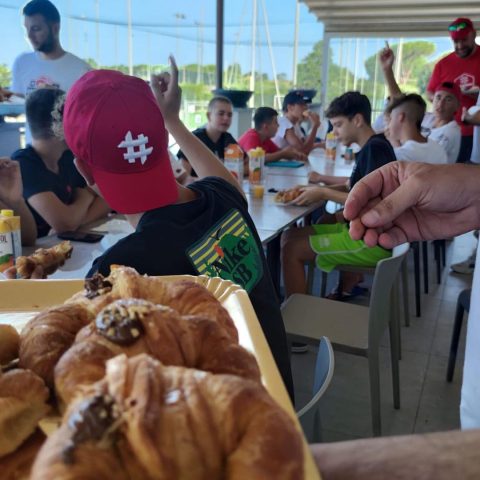 Colazione al camp: vassoio di cornetti e un ragazzo con il cappellino Maisenza
